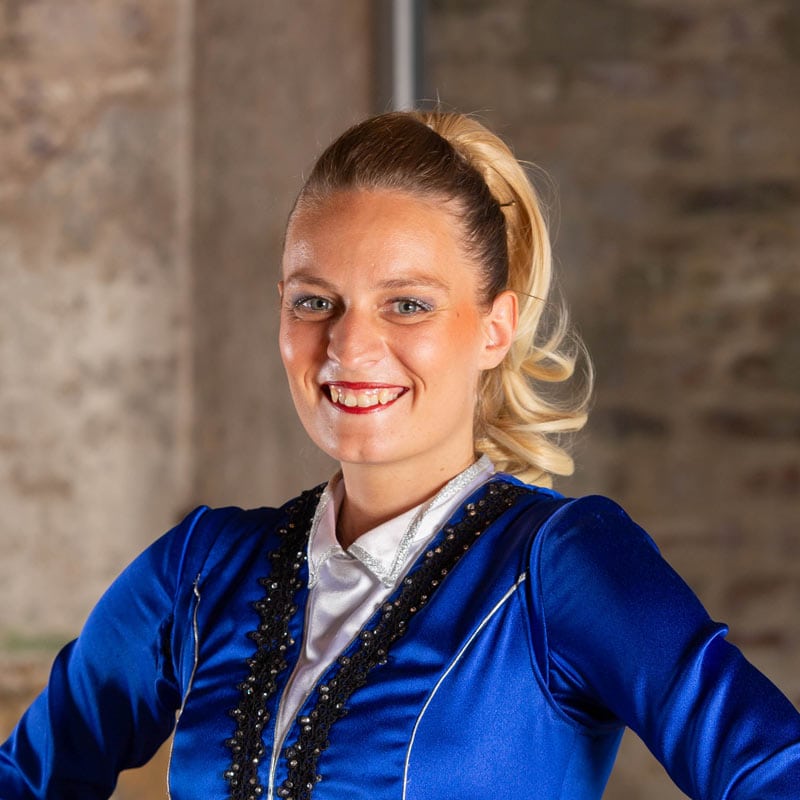 Frau in blauem Kostüm lächelt vor Kamera