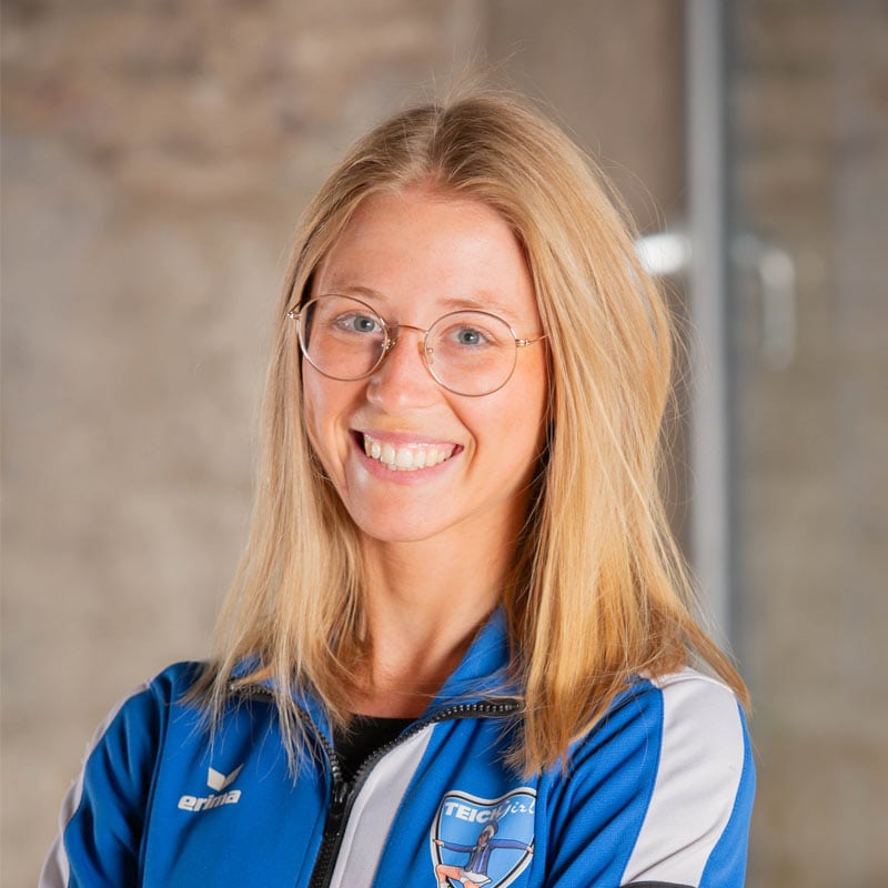 Lächelnde Frau in blauem Sportjacke
