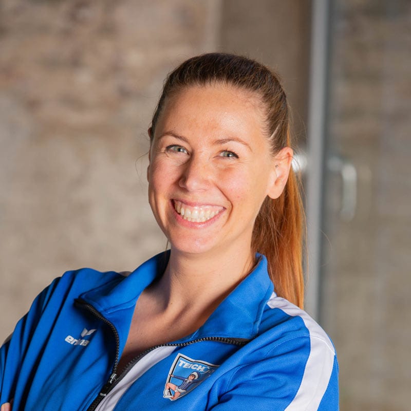 Lächelnde Frau in blauer Sportjacke