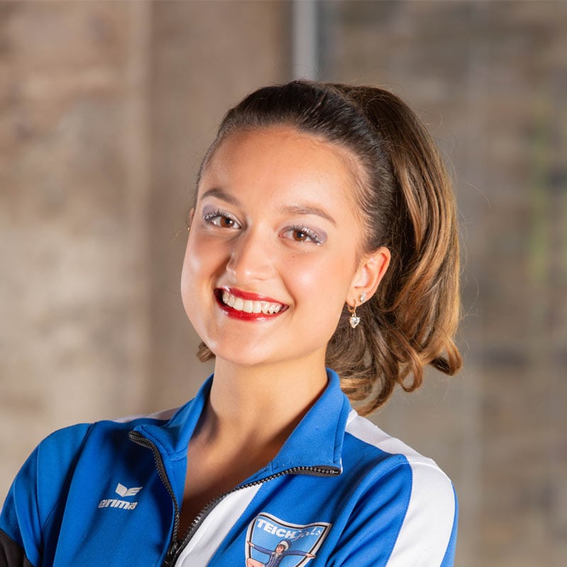 Lächelnde Sportlerin im blauen Vereinsanzug
